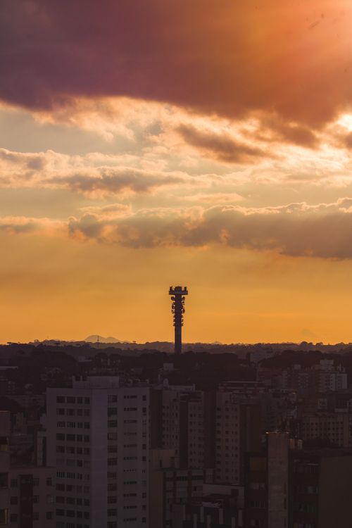 Free A breathtaking urban sunset over city buildings with dramatic clouds and an aerial view. Stock Photo