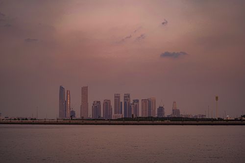 Free Stunning view of Dubai's skyline at dusk, featuring tranquil sea and skyscrapers. Stock Photo