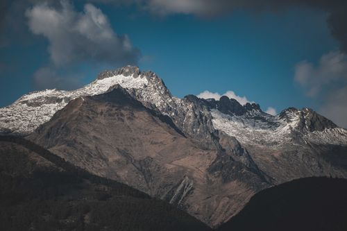 Free Stunning view of snow-capped alpine mountains under a blue sky with scattered clouds, perfect for nature lovers. Stock Photo