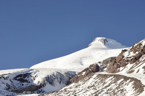 Foto profissional grátis de céu azul, coberto de neve, colina