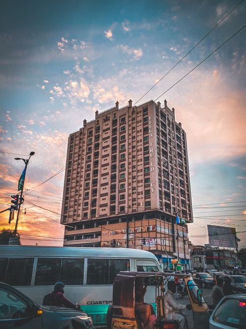 Free High-rise building with busy city traffic at sunset, showcasing urban life and architectural design. Stock Photo