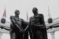 Historic statues at Hemicycle de la Rotonda, Guayaquil, Ecuador, captured with flags in the background.