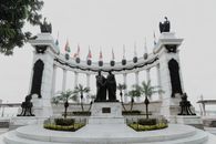 A historic monument featuring statues and flags in Guayaquil, Ecuador symbolizing independence and unity.