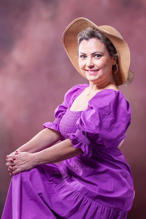 Smiling Woman in Hat and Purple Dress