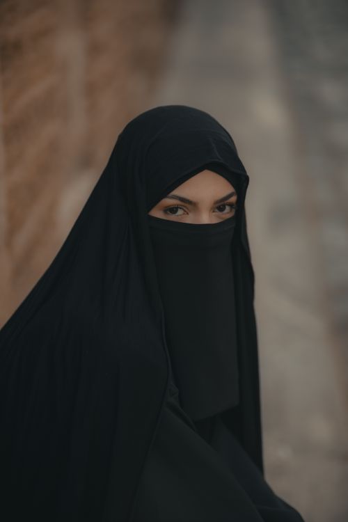 Free A woman wearing a black hijab in a traditional setting. The focus is on the cultural attire and pose. Stock Photo