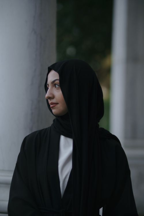 Free Stylish portrait of a young woman in a black hijab posing outdoors. Stock Photo