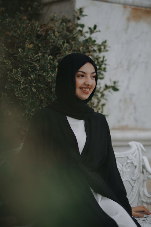 Young Woman in a Hijab Sitting Outside and Smiling 