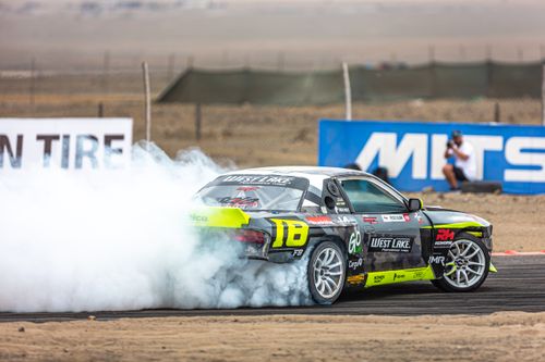 Free A powerful drift car performing on a racetrack, leaving a trail of smoke in its wake. Stock Photo