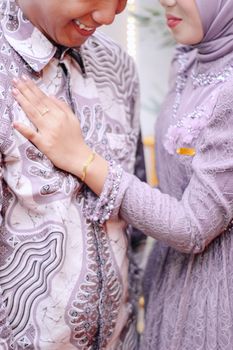 A close-up of a couple affectionately embracing in modern, elegant lilac attire. - Fotografer Sidoarjo