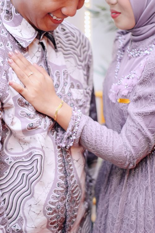Free A close-up of a couple affectionately embracing in modern, elegant lilac attire. Stock Photo