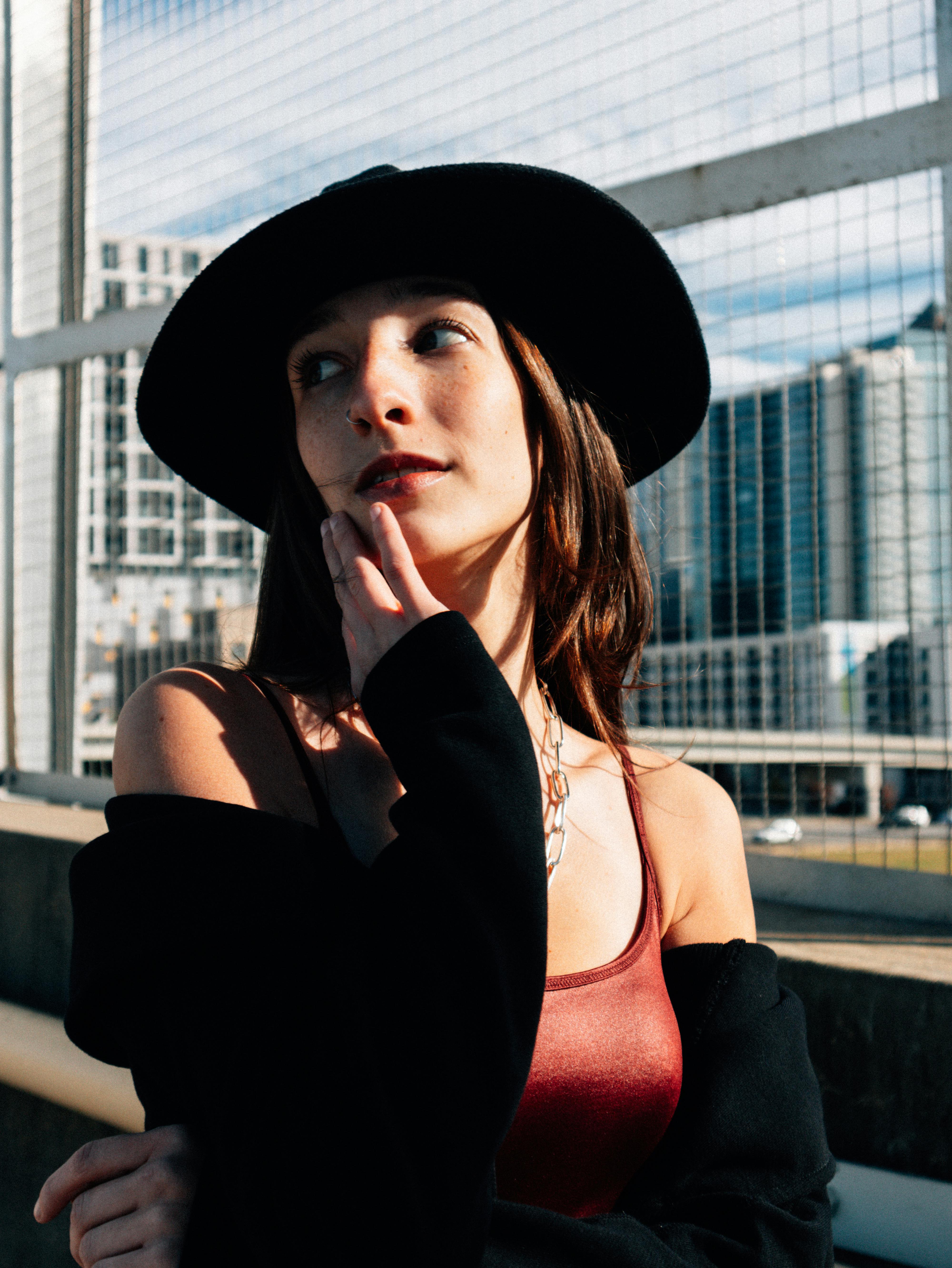 a woman in a black hat and red dress