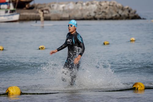 Free A triathlete in sportswear emerges from the ocean during a race. Stock Photo