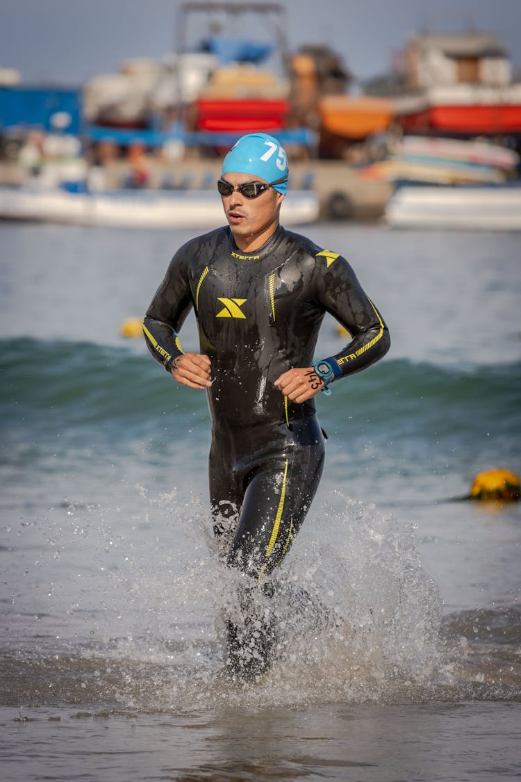 Swimmer In Swimsuit Running On Seashore