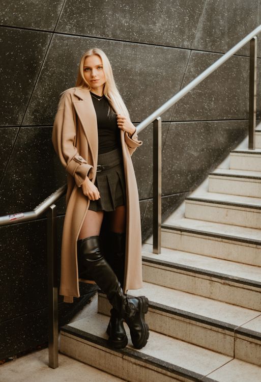Woman in trench coat with skirt and boots