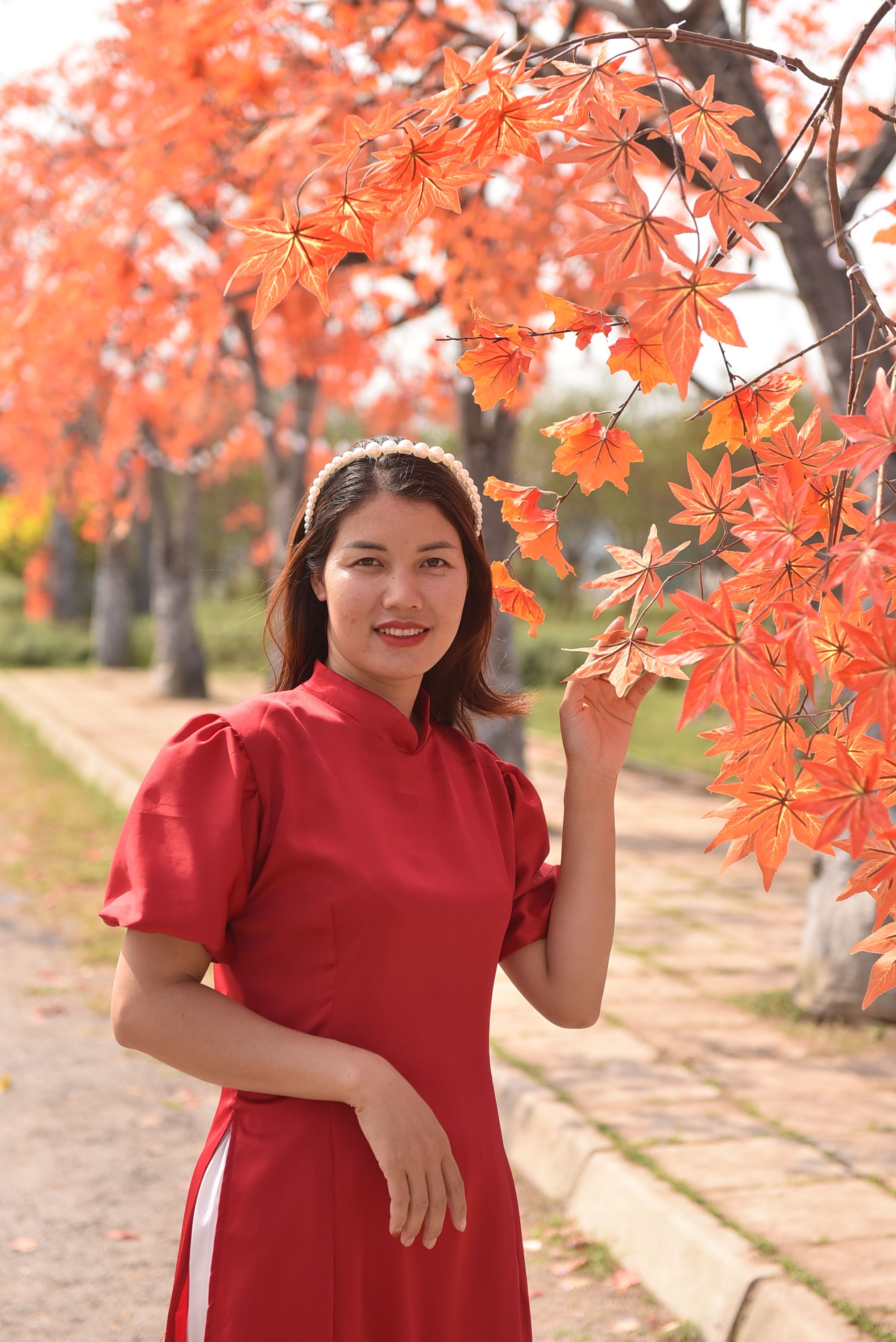 A woman in a red dress standing next to a tree · Free Stock Photo