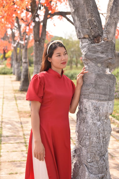 Portrait of Woman in Red Dress Standing by Tree