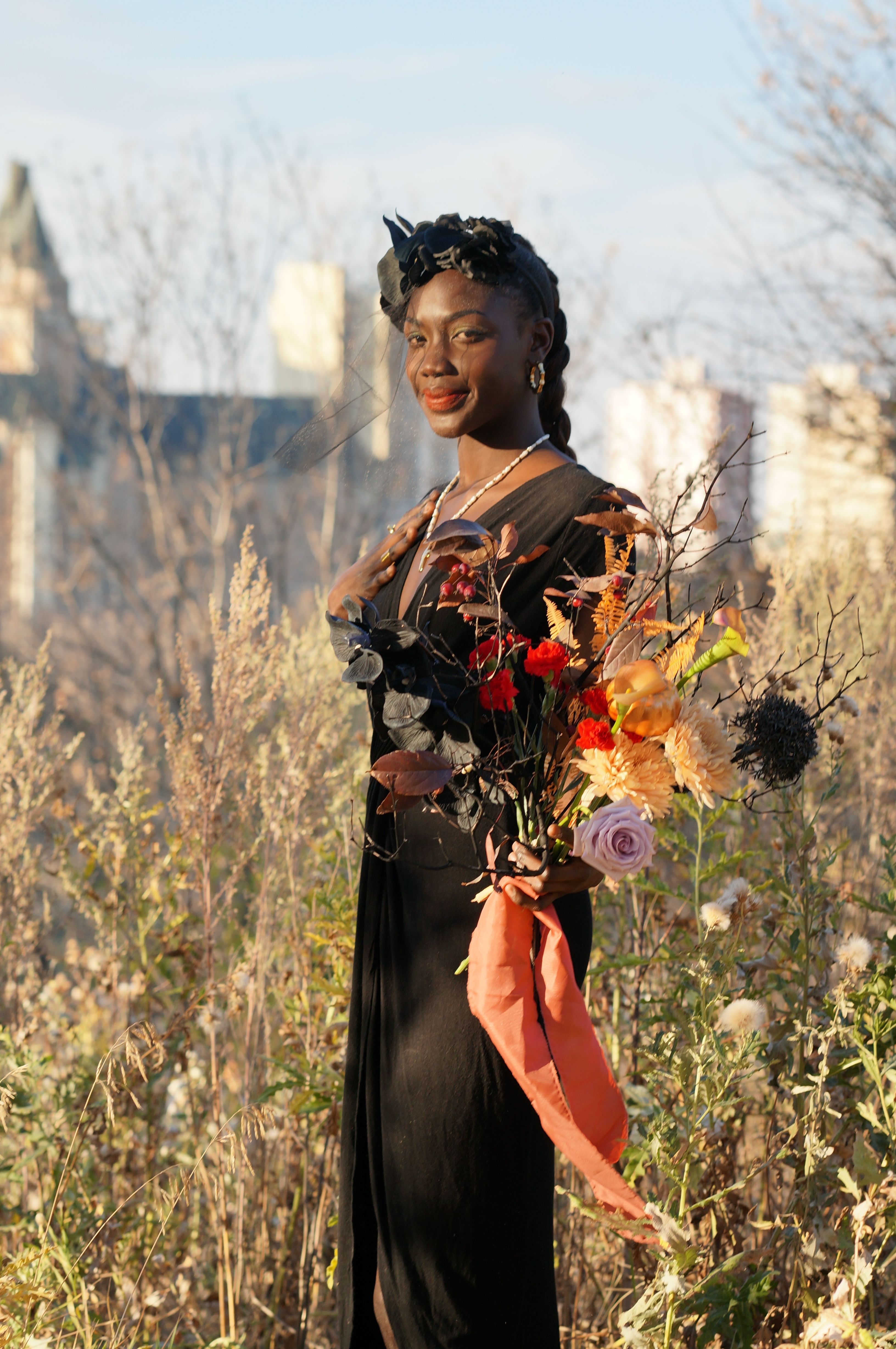 Woman in Black Dress Standing with Flowers on Meadow · Free Stock Photo