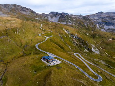 Dramatic aerial shot showcasing a winding mountain road through the barren alps in Austria.