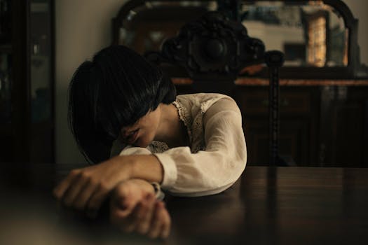 一位女子深思熟虑后，将头靠在了抛光的木桌上