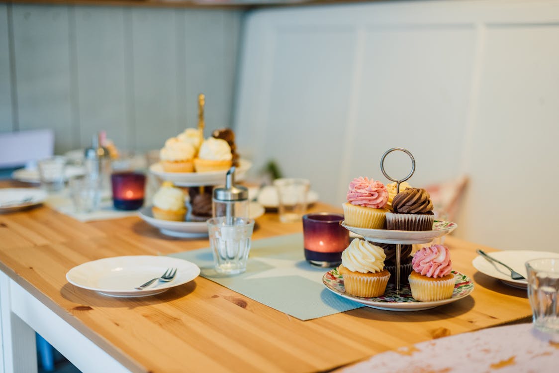 A Table with Cupcakes and Tableware 