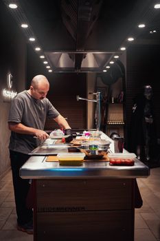 Chef focused on preparing a gourmet meal in a luxurious, modern kitchen setting.