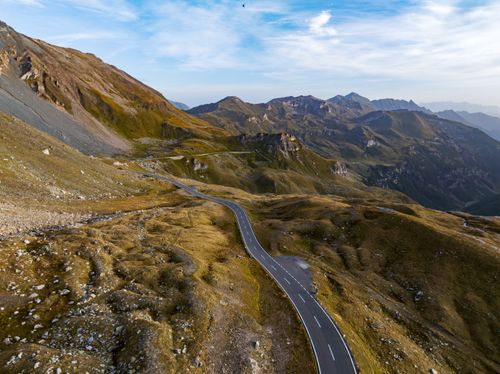 Free Aerial view of a winding road through the stunning mountains of Hochtor, Austria. Stock Photo