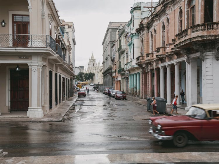 Alley With Colonial Buildings And Vintage Cars In A Cuban City 