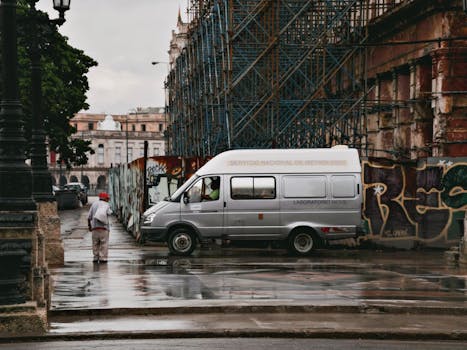 A rainy day in Havana featuring a van, street graffiti, and urban architecture.