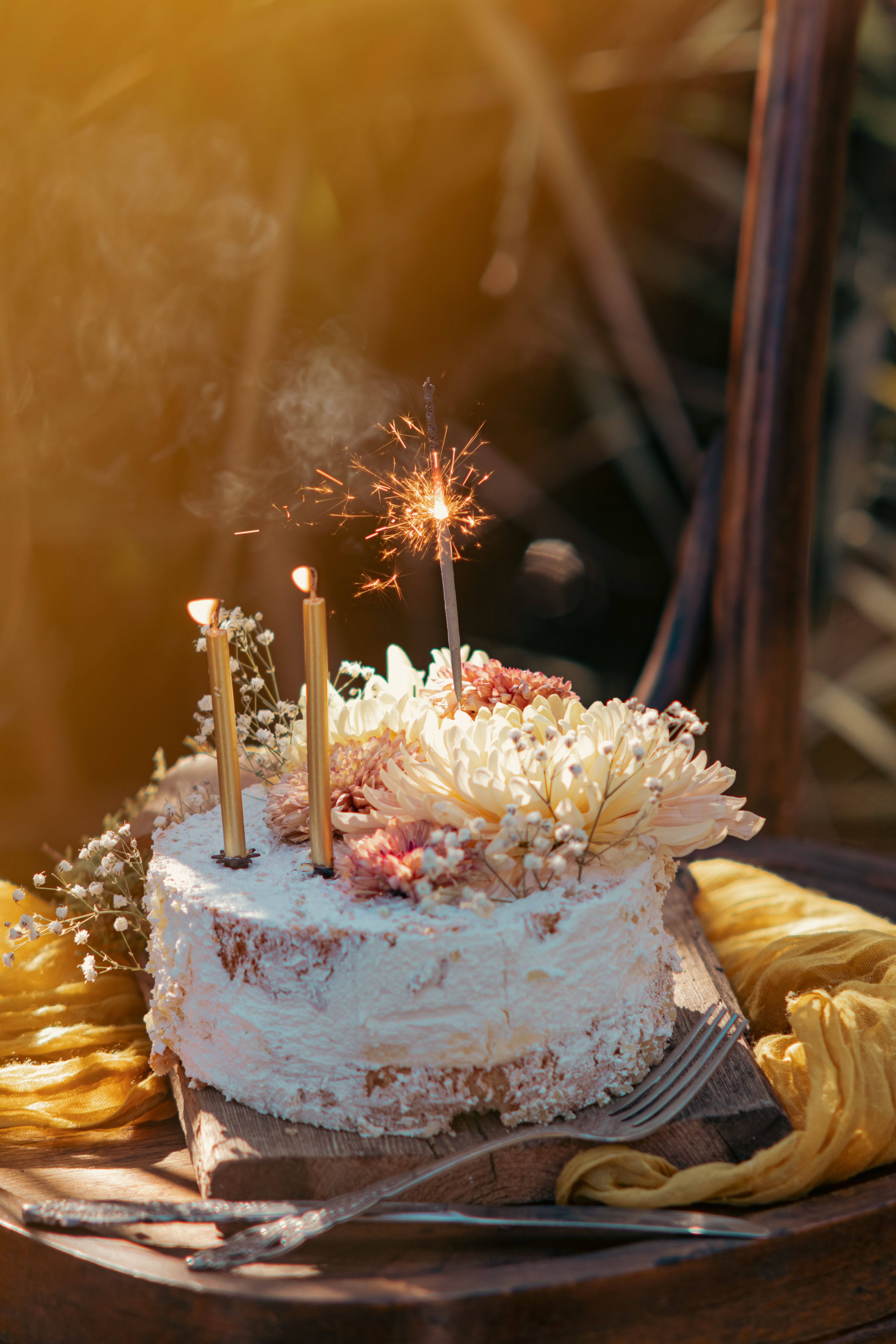 Cake with sparkler and flowers, photo by Orhan Pergel on Pexels