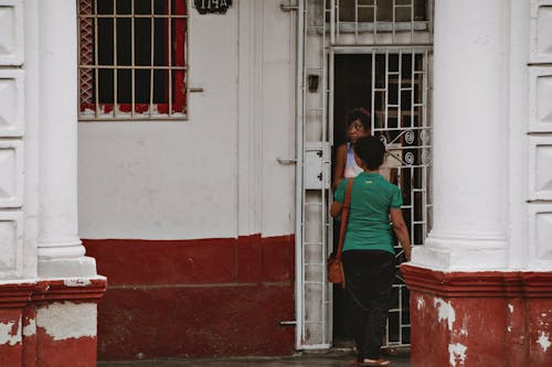 Two People Standing by a Door 