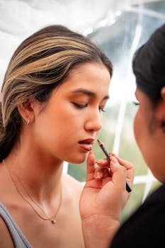 Professional makeup artist applying lip liner to a young woman's lips with precision, enhancing her beauty.