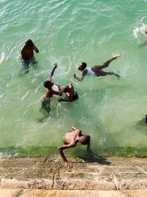 Free A group of teenagers playfully swimming and enjoying in a clear lake, seen from above. Stock Photo