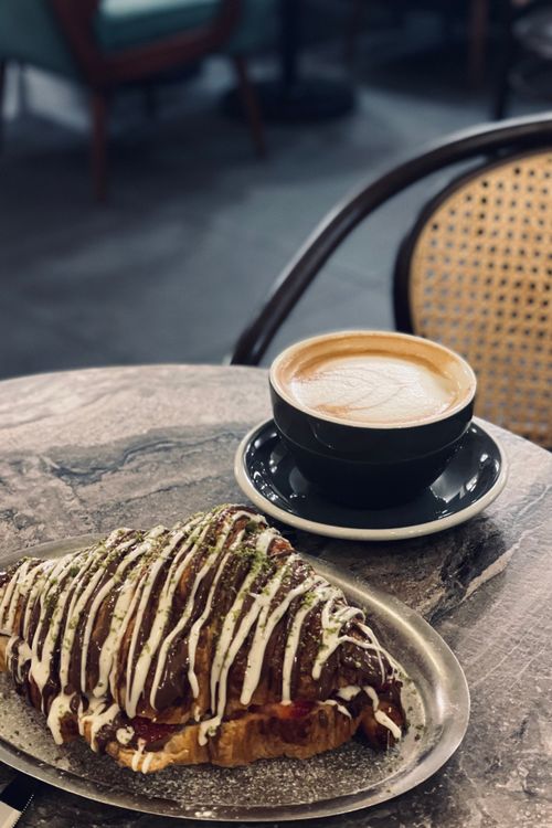 Free Enjoy this tasty coffee and pastry on a stylish marble table, perfect for cafe lovers. Stock Photo