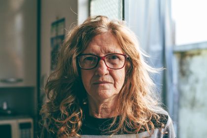 Elderly woman with red eyeglasses and wavy hair in natural light indoors — photo by Fernando Lucas on Pexels