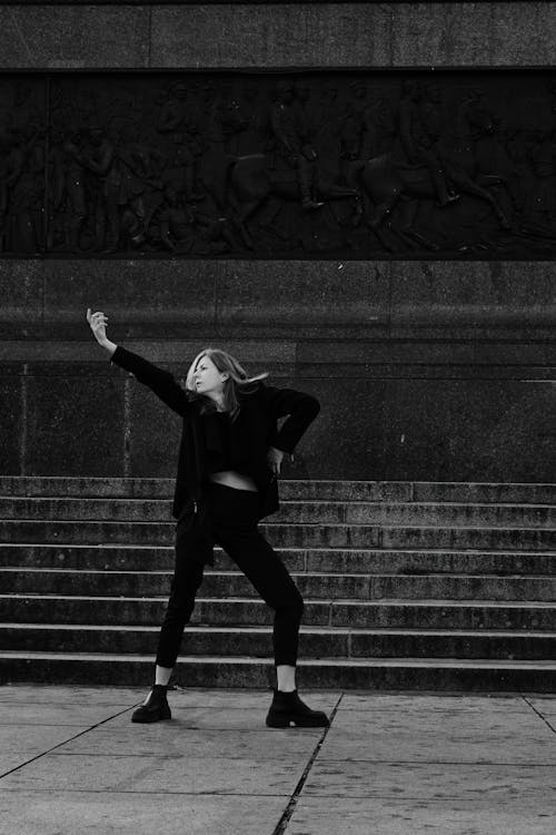 Black and White Analogue Photo of a Woman Dancing on Steps