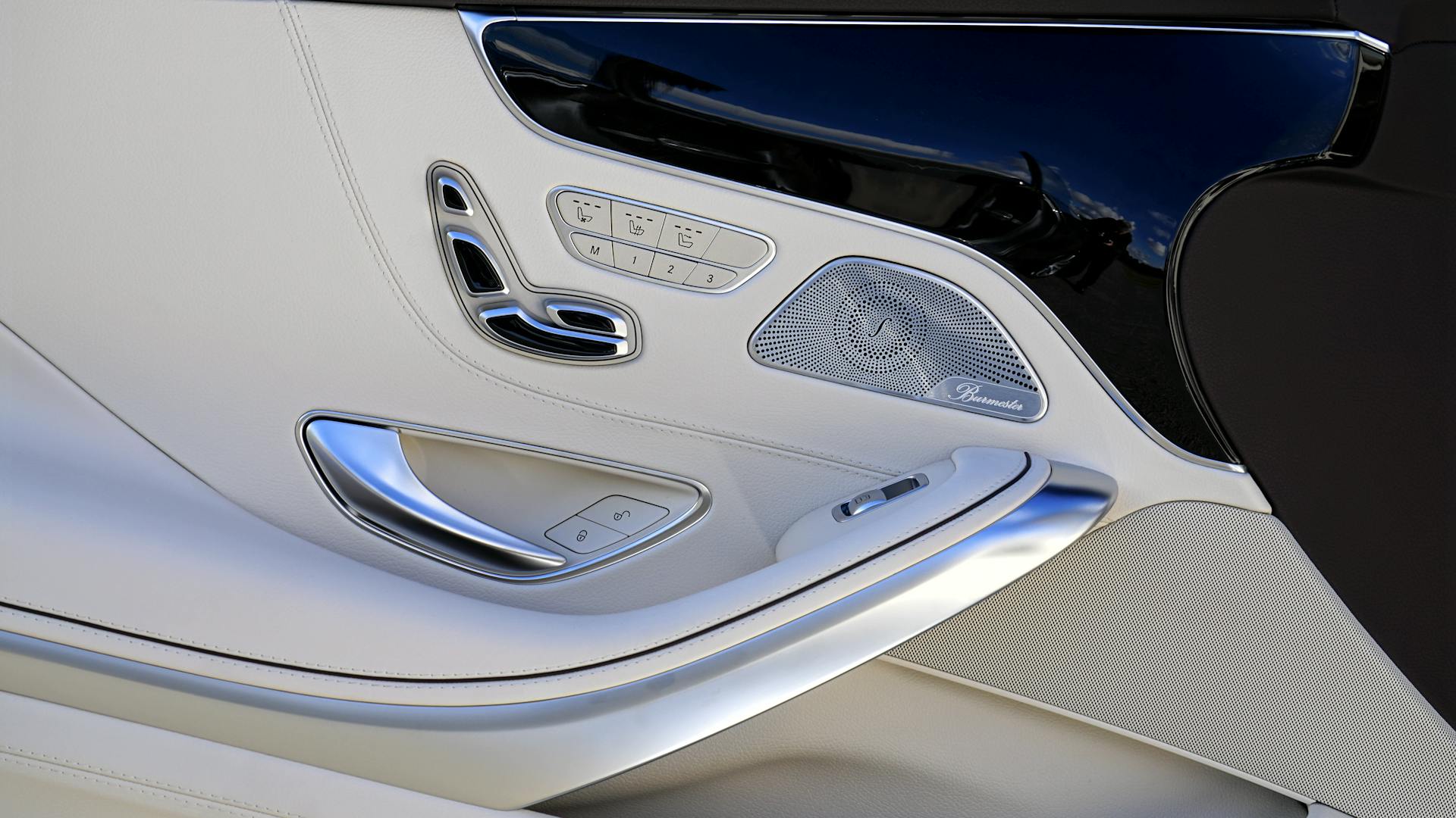 Close-up view of a luxury car door interior showcasing sleek design and technology.