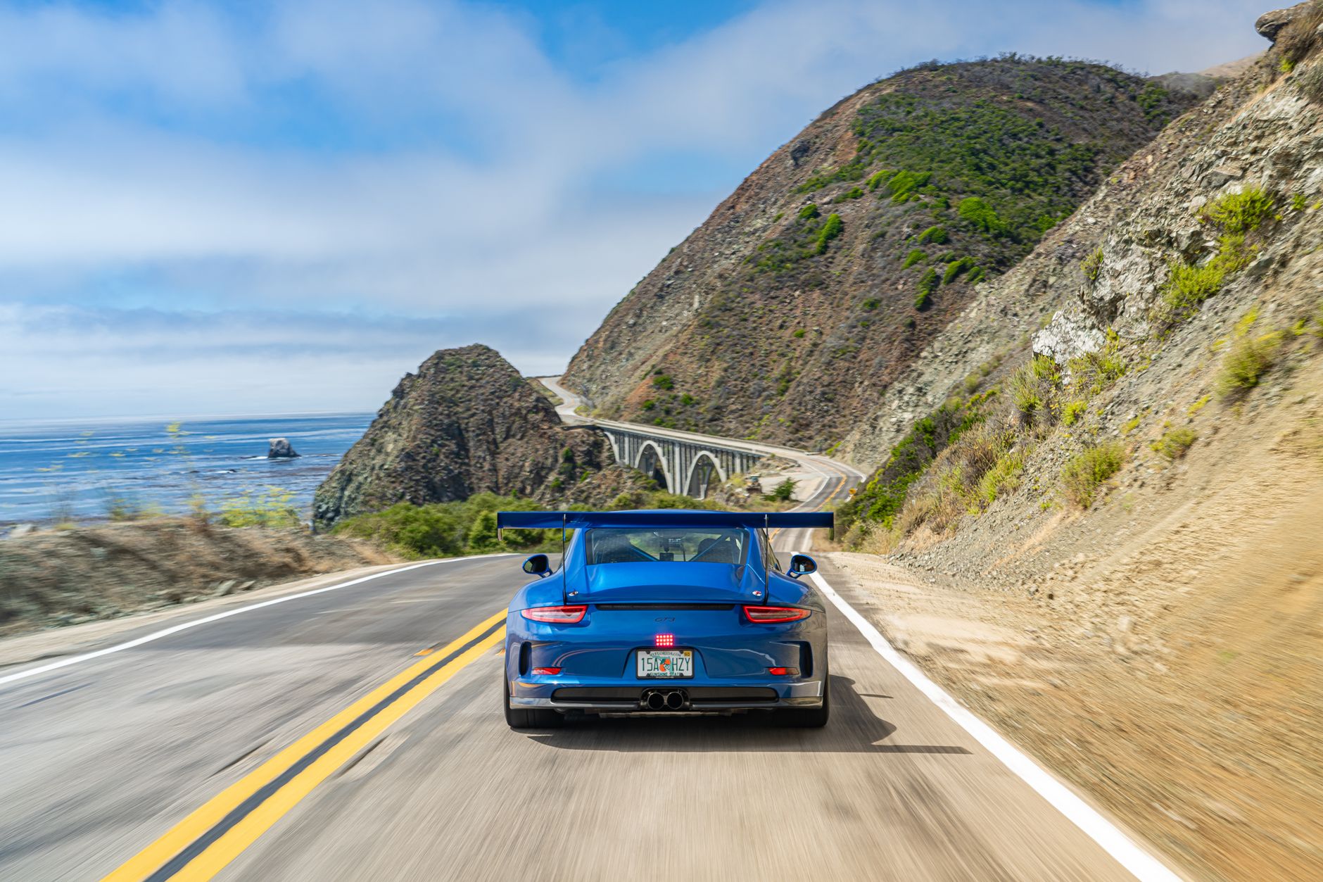 A father enjoying a luxury sports car drive along the California coast