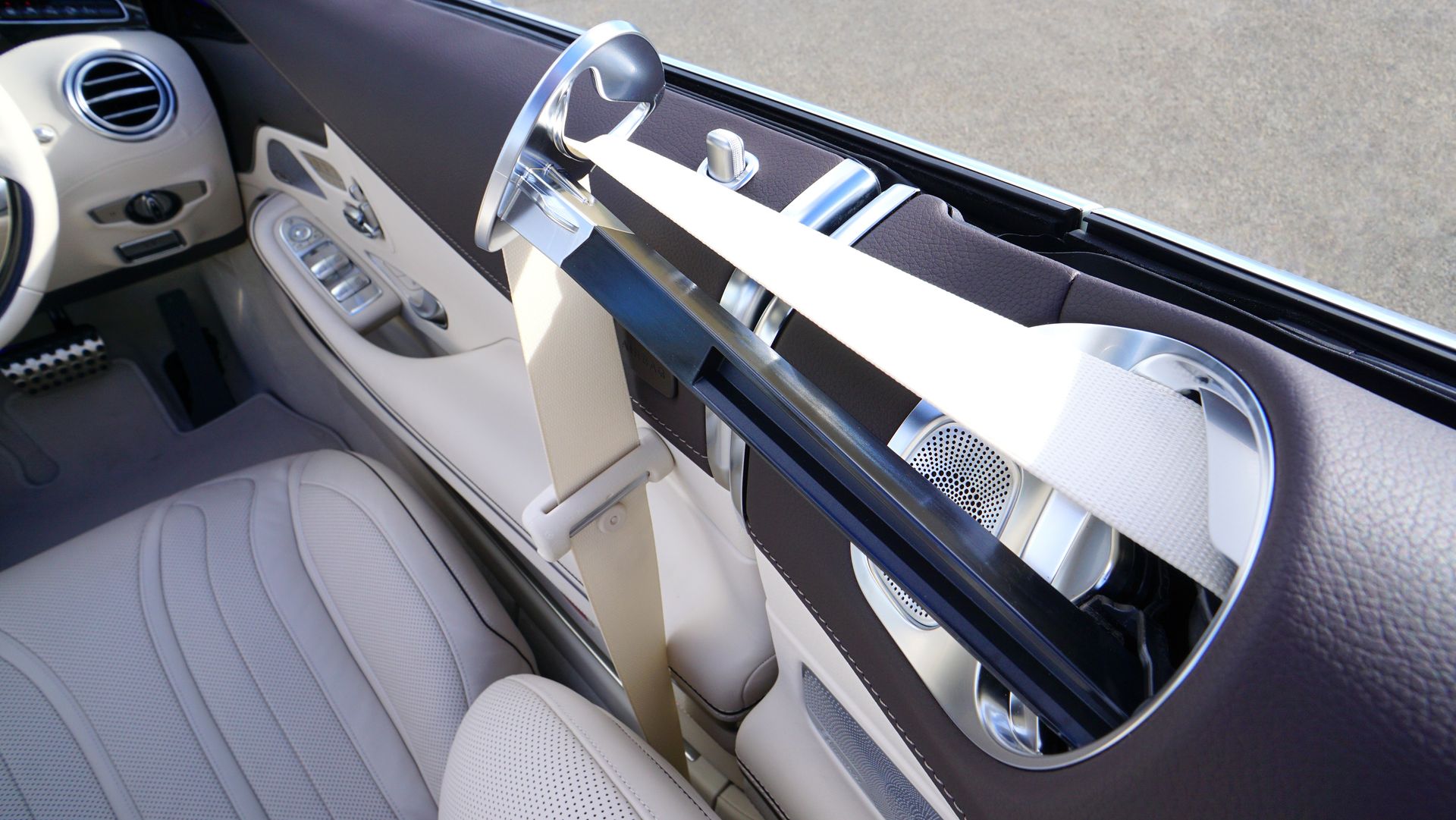 Close-up view of a luxury car interior featuring beige leather seats and modern design elements.