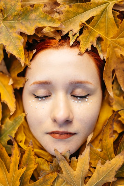 Womans Face Among Yellow Leaves 