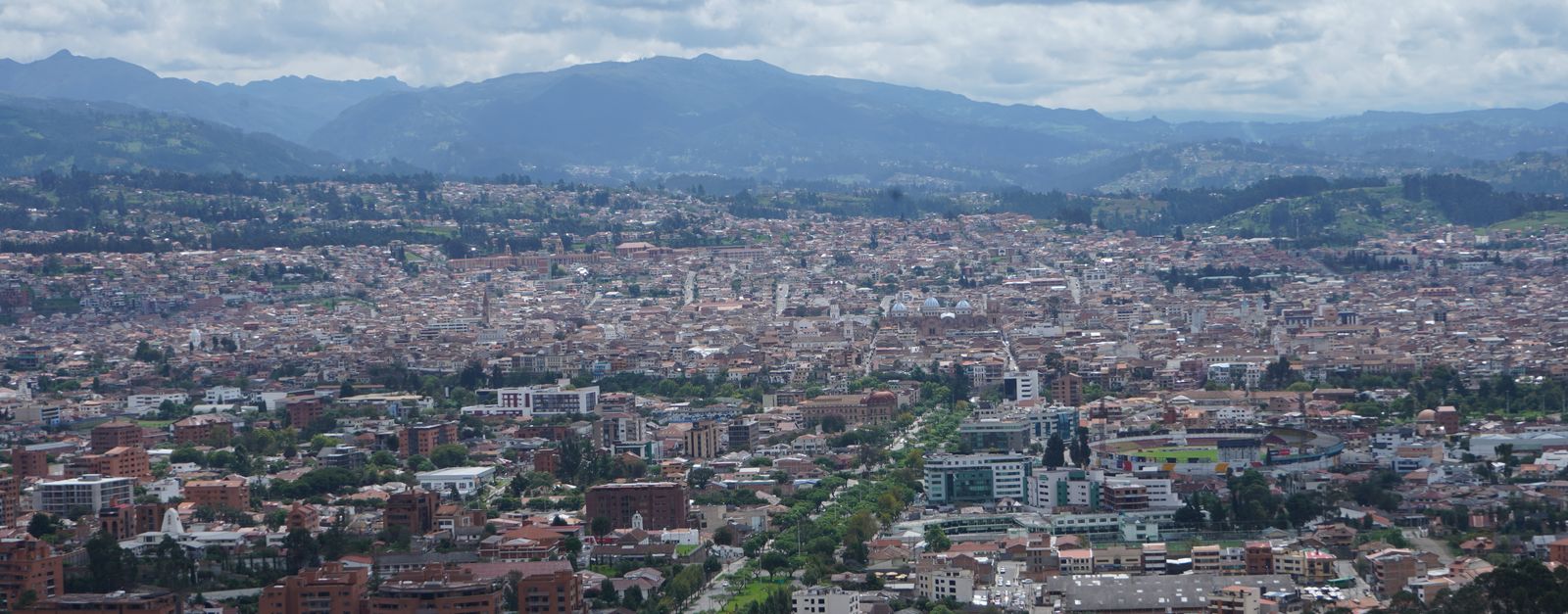 Stunning aerial view of Cuenca, Ecuador showcasing its dense urban landscape and mountainous backdrop.