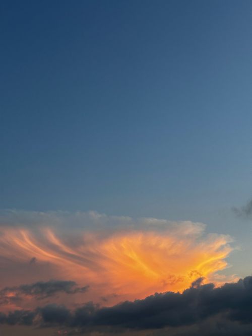Free Captivating sunset cloudscape with vibrant orange hues against a clear sky, perfect for nature backgrounds. Stock Photo