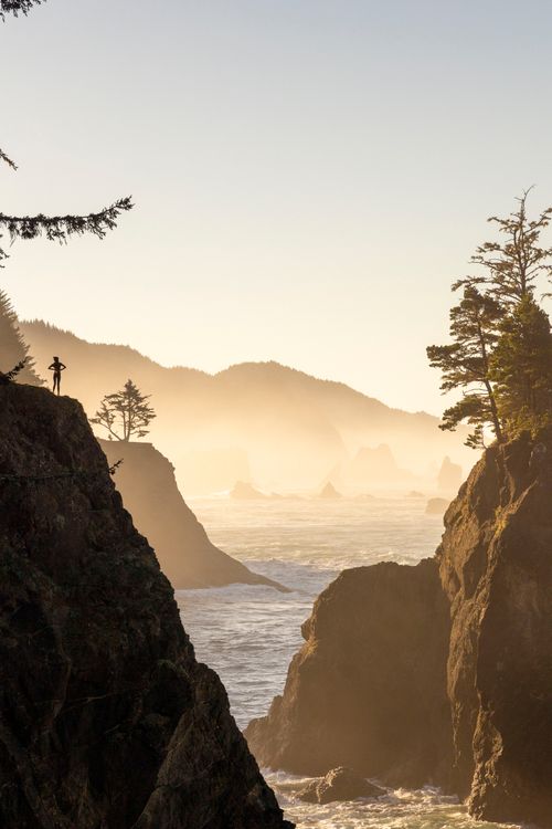 Free A breathtaking coastal landscape with mist and cliffs at sunset, perfect for travel inspiration. Stock Photo
