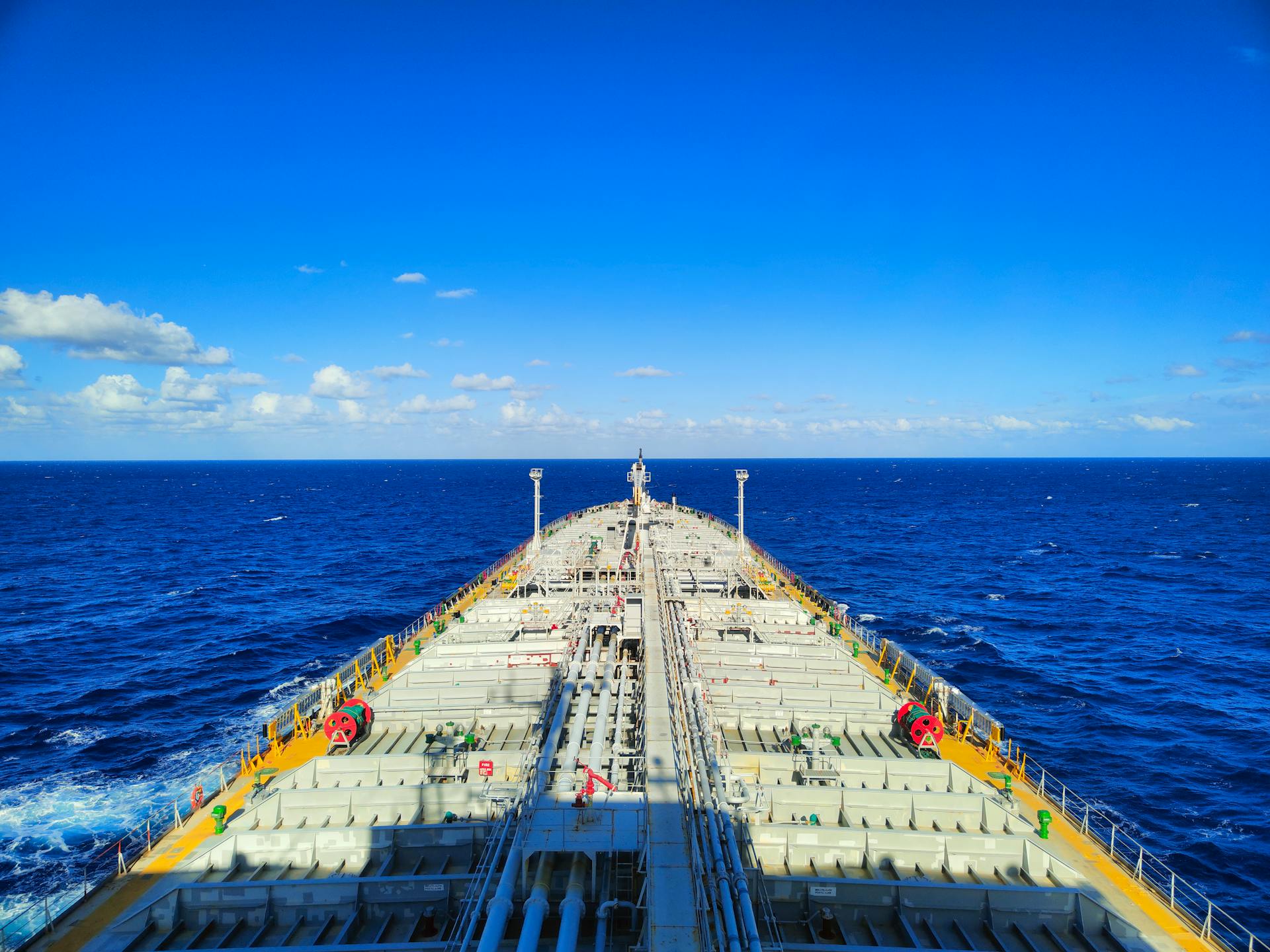 Aerial view of a large shipping tanker amidst a clear blue sky and ocean.