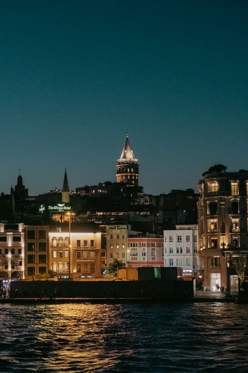 Free Stunning night view of Istanbul's Galata Tower illuminating the vibrant city skyline by the Bosphorus. Stock Photo