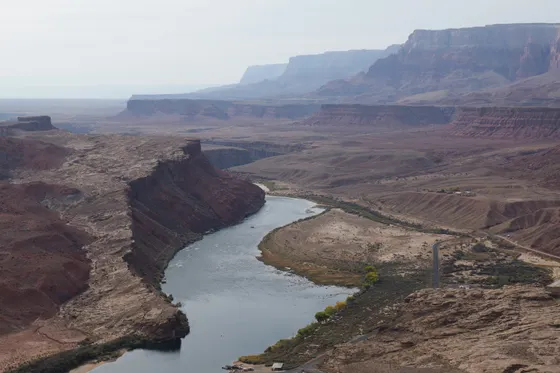 The calm green Colorado River winding through Glen Canyon below the dam