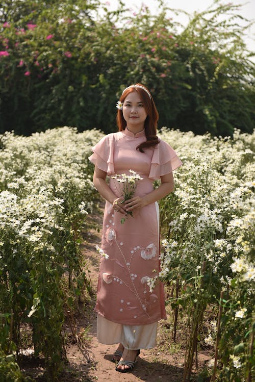 Woman in Pink Dress Standing with Flowers