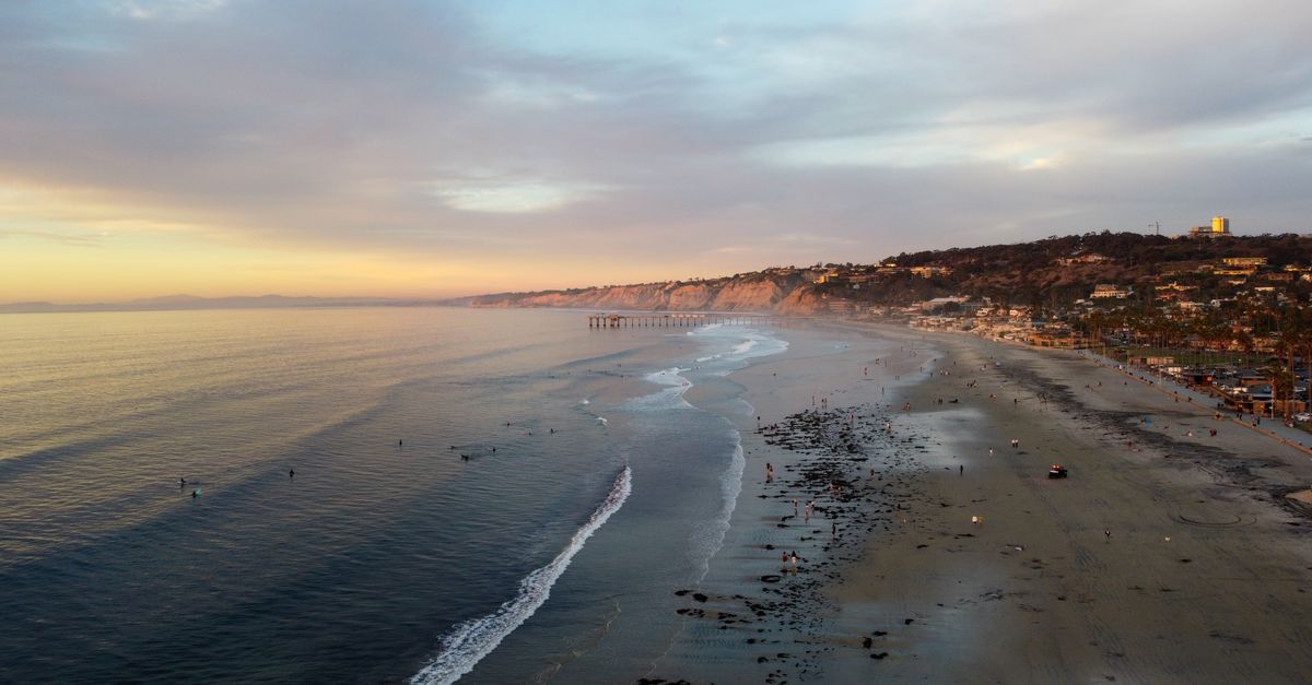 Stunning aerial view of San Diego beach with gentle waves at sunset.