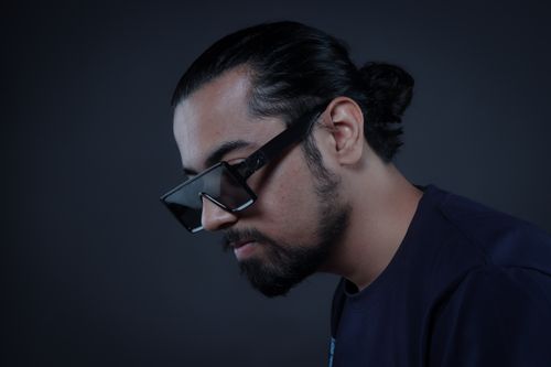 Free Profile shot of a stylish man with sunglasses and beard, exuding modern fashion in a studio setting. Stock Photo