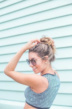 一位戴着太阳镜的女人在户外淡蓝色的背景下微笑