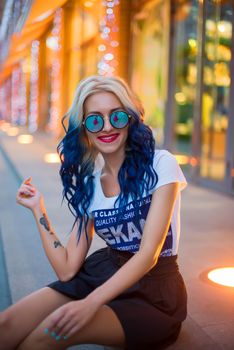 Stylish woman in sunglasses enjoys a warm evening outdoors in Madrid.